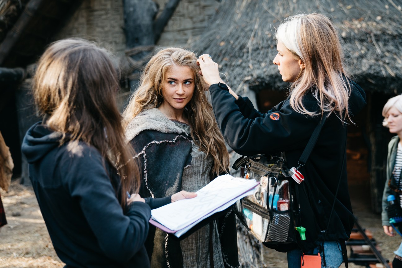 A makeup artist adjusts an actress's hair on the set of The Barbarians during filming in Hungary.