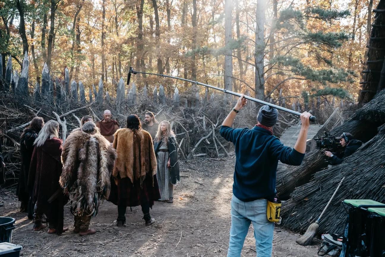 Film crew shooting a scene with costumed actors in a forest setting for Netflix series The Barbarians.