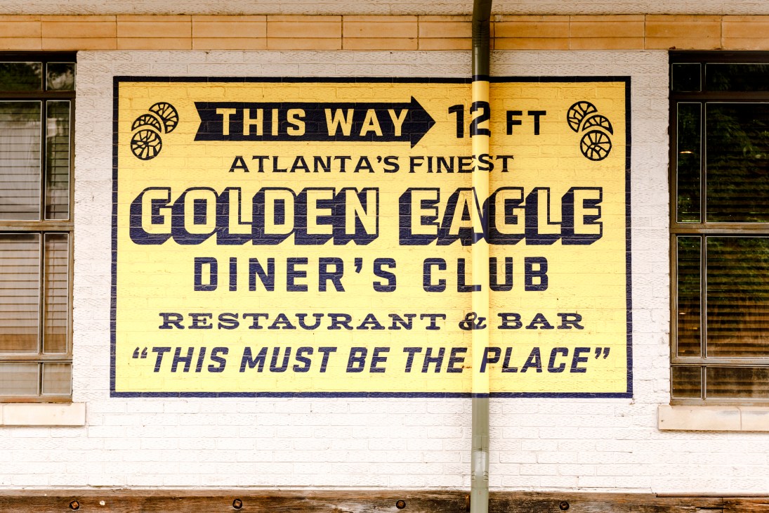 Yellow and black vintage-style painted wall sign for Golden Eagle Diner's Club advertising Atlanta's finest restaurant