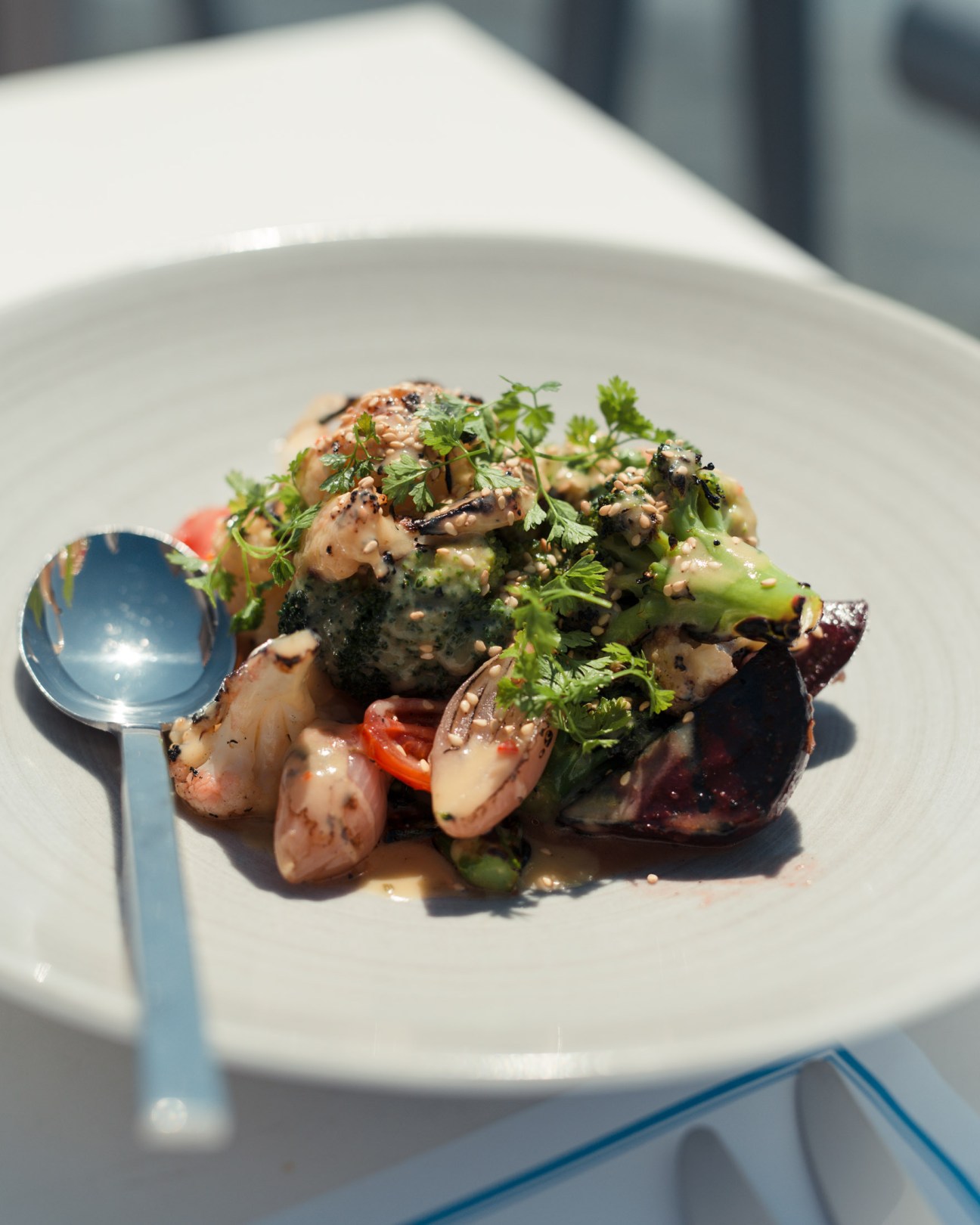Plated seafood dish with octopus, vegetables and herbs at BlueFish restaurant.