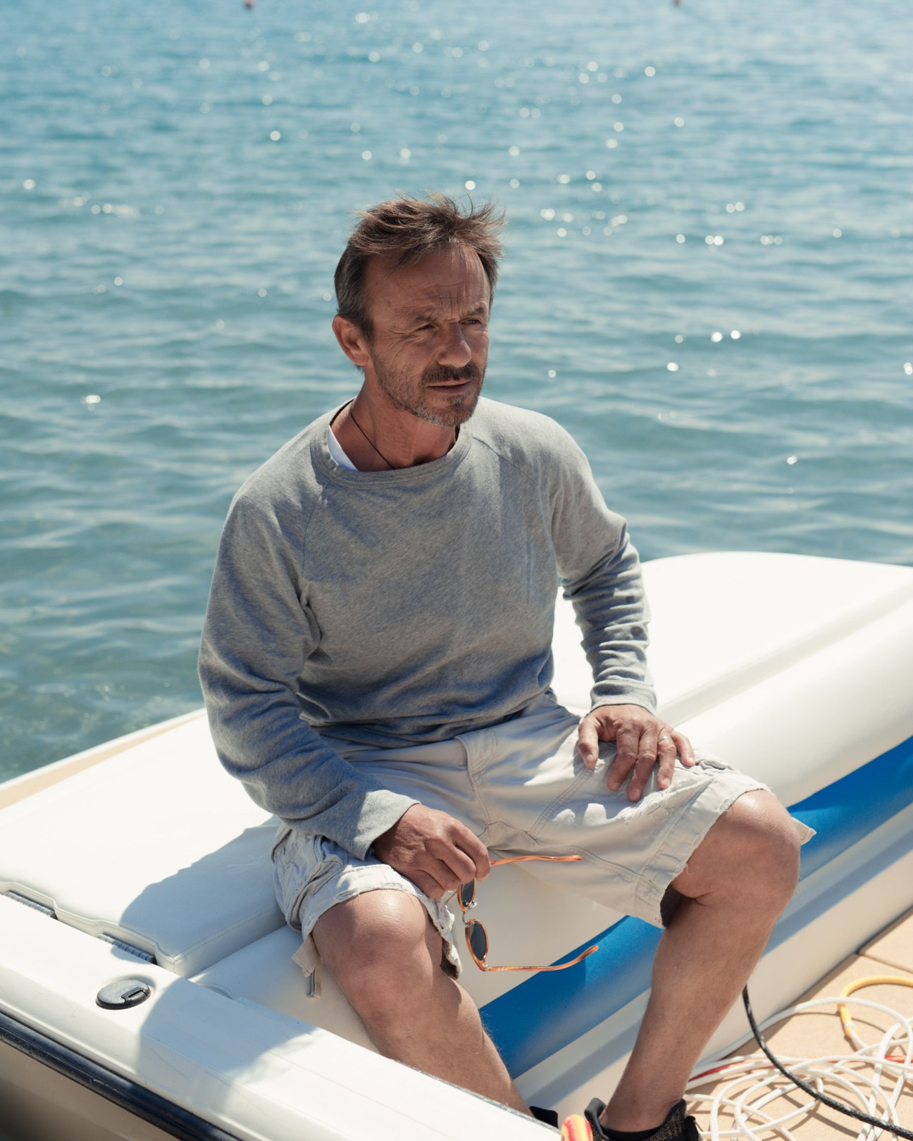 Lolos Stamatis, legendary water-ski instructor, sitting on a boat in Vouliagmeni bay.