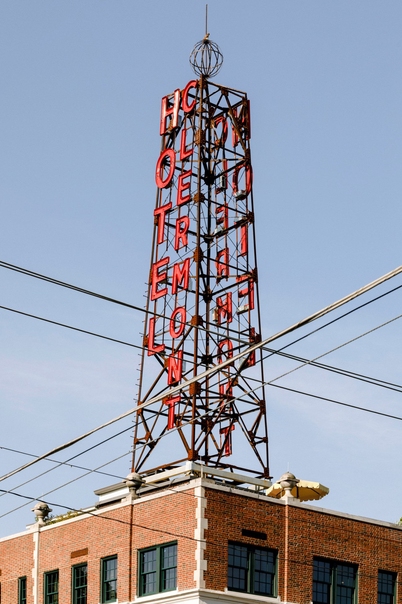 Hotel Clermont's tower with red neon sign reading 'HOTEL CLERMONT' on metal framework structure