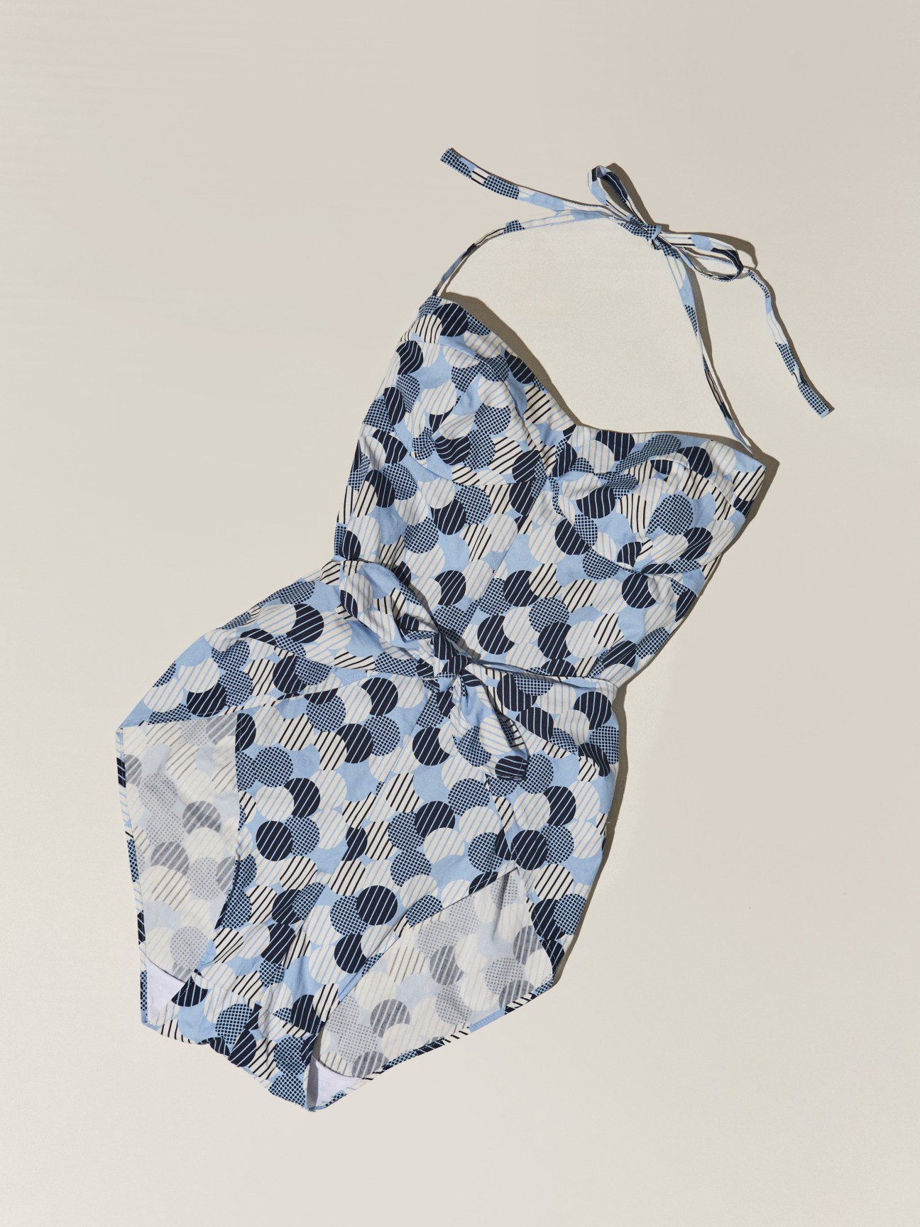 Blue and white patterned one-piece swimsuit by Miu Miu with halter neckline on neutral background.