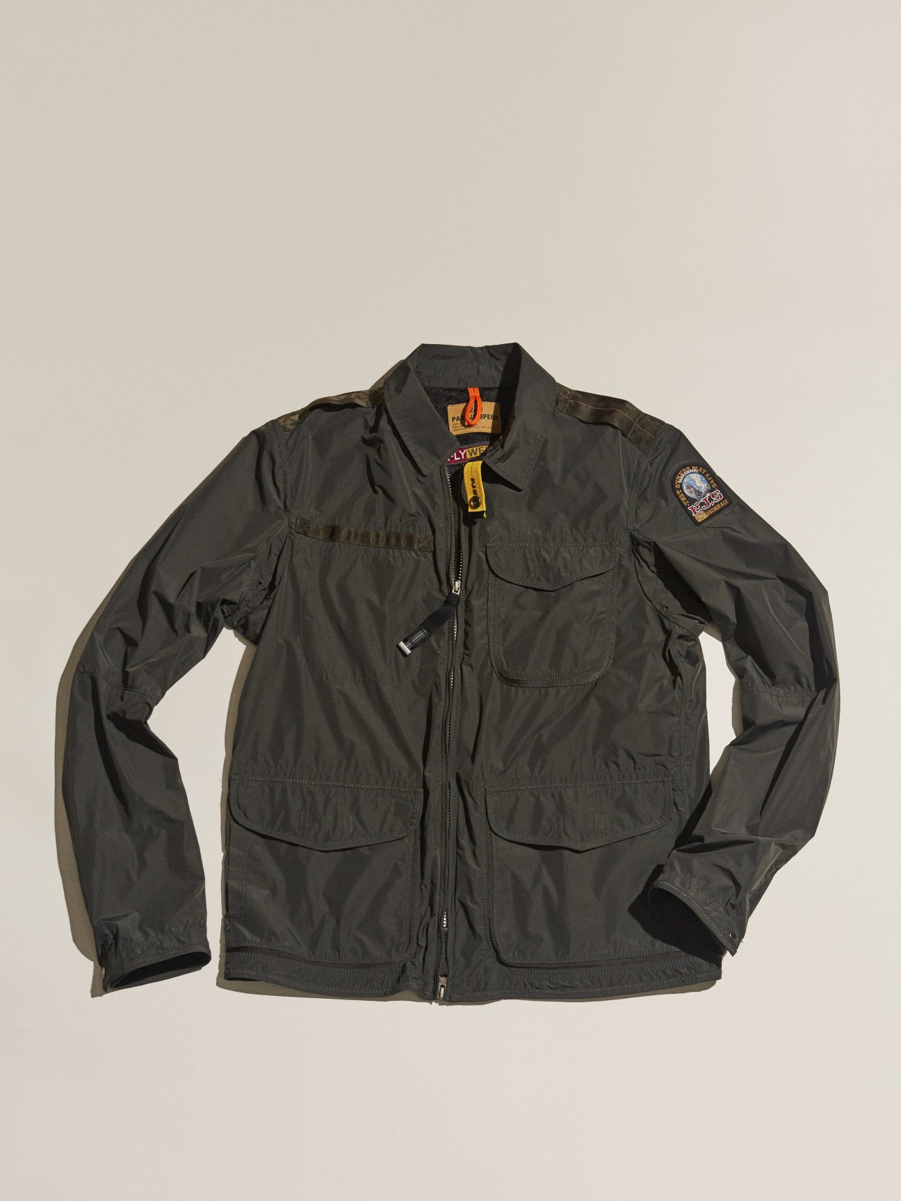 Dark gray Parajumpers jacket with multiple pockets and branded shoulder patches displayed on neutral background.
