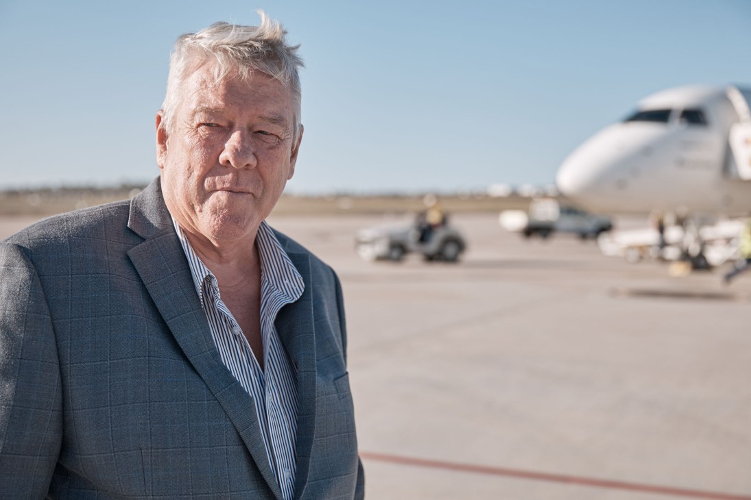 John Wagner, co-founder of Brisbane West Wellcamp Airport, standing on the tarmac with aircraft in background.