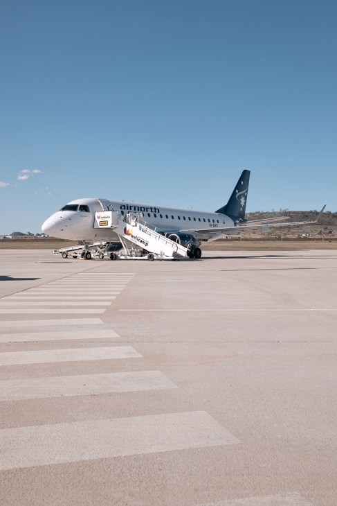 Airnorth regional passenger aircraft parked at Wellcamp Airport tarmac with boarding stairs attached.