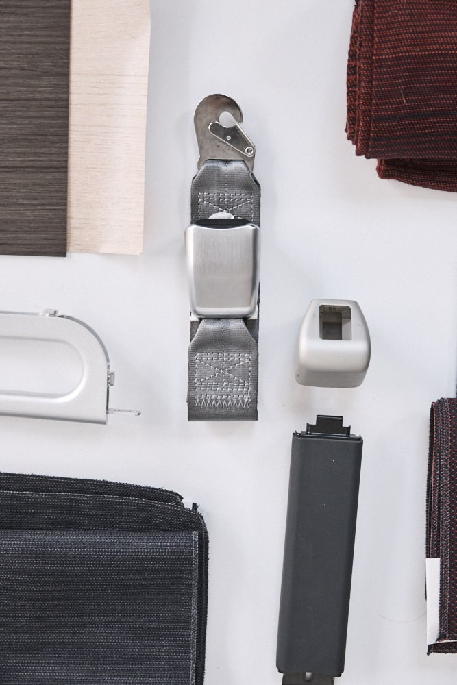 Cabin components displayed at David Caon's studio including textured fabric straps, metal buckles, and various material swatches.