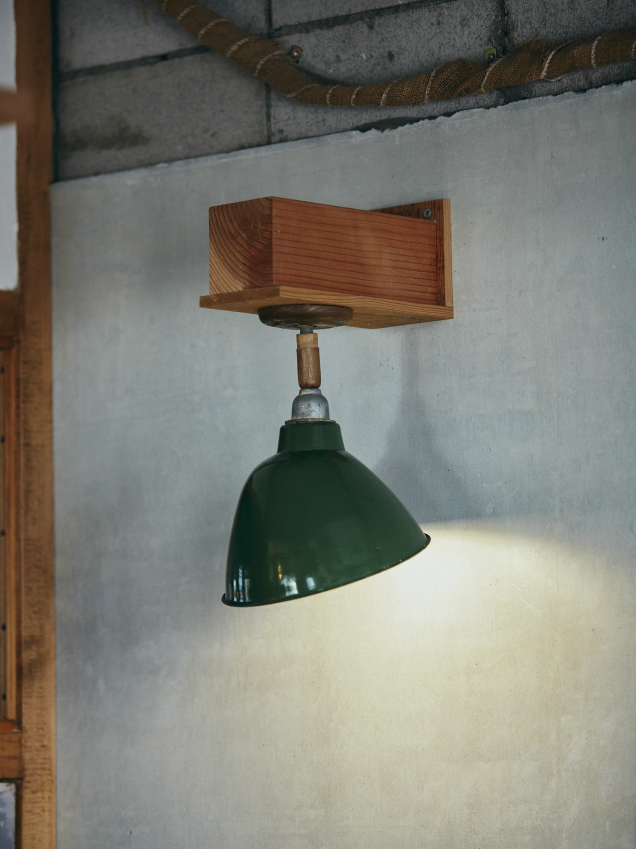 Wooden ceiling-mounted fixture with green dome-shaped pendant light and rope detail at Hotel Aiaoi