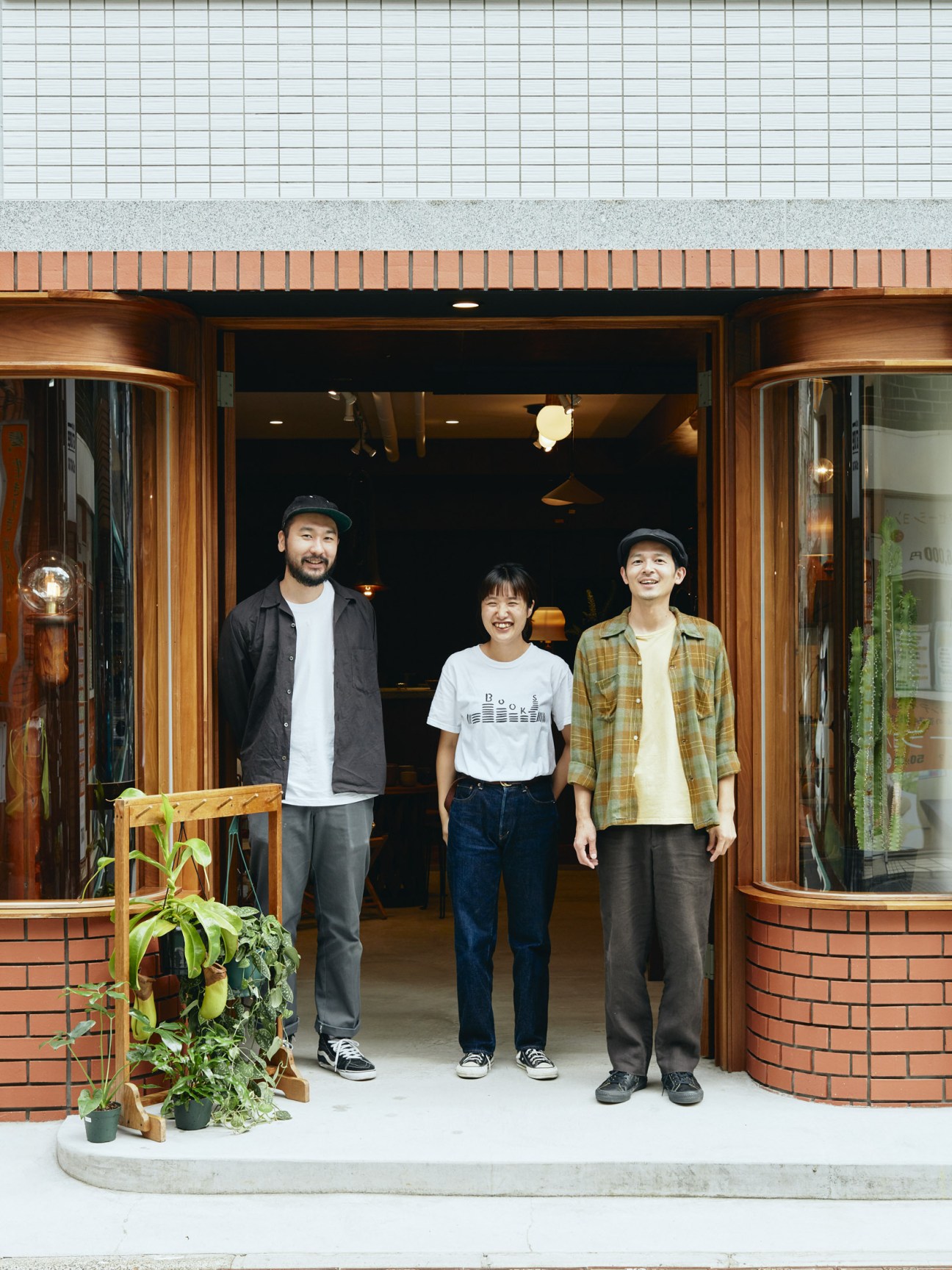 Daisuke Matsushima and two staff members stand in the doorway of Bullpen furniture shop in Tokyo.
