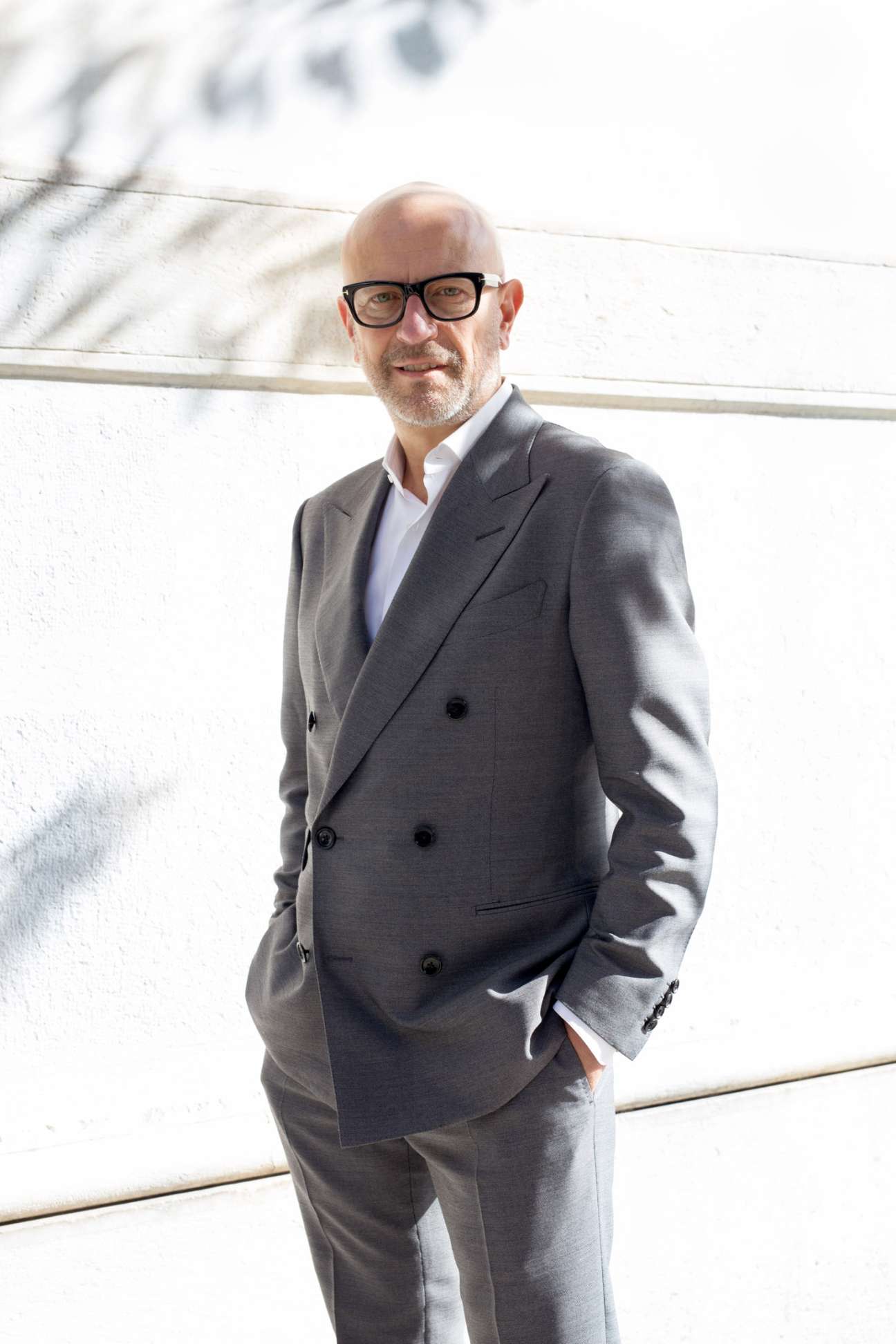 Beppe Nugnes, CEO of Nugnes 1920 boutique, wearing a grey double-breasted blazer and glasses