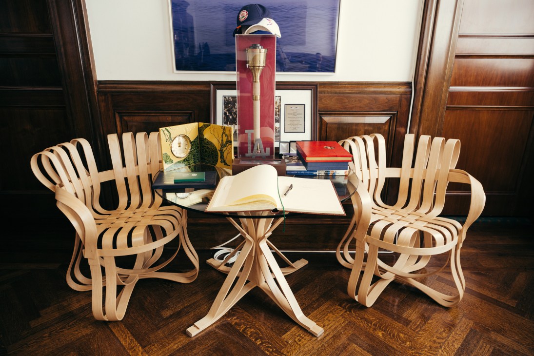 Interior of mayor's office with curved wooden chairs around small table and open guestbook.