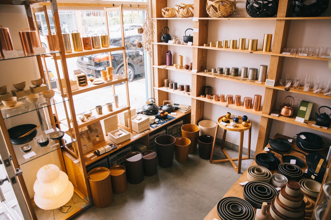 Interior view of Tortoise General Store with wooden shelving displaying candles, kitchenware, and home goods.