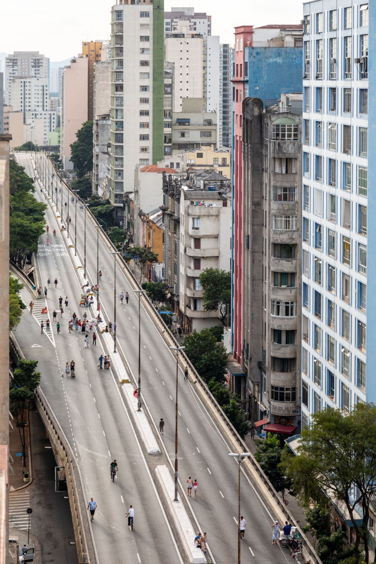 Aerial view of Minhocão Park in São Paulo showing elevated highway with pedestrians and surrounding mixed-architecture cityscape.