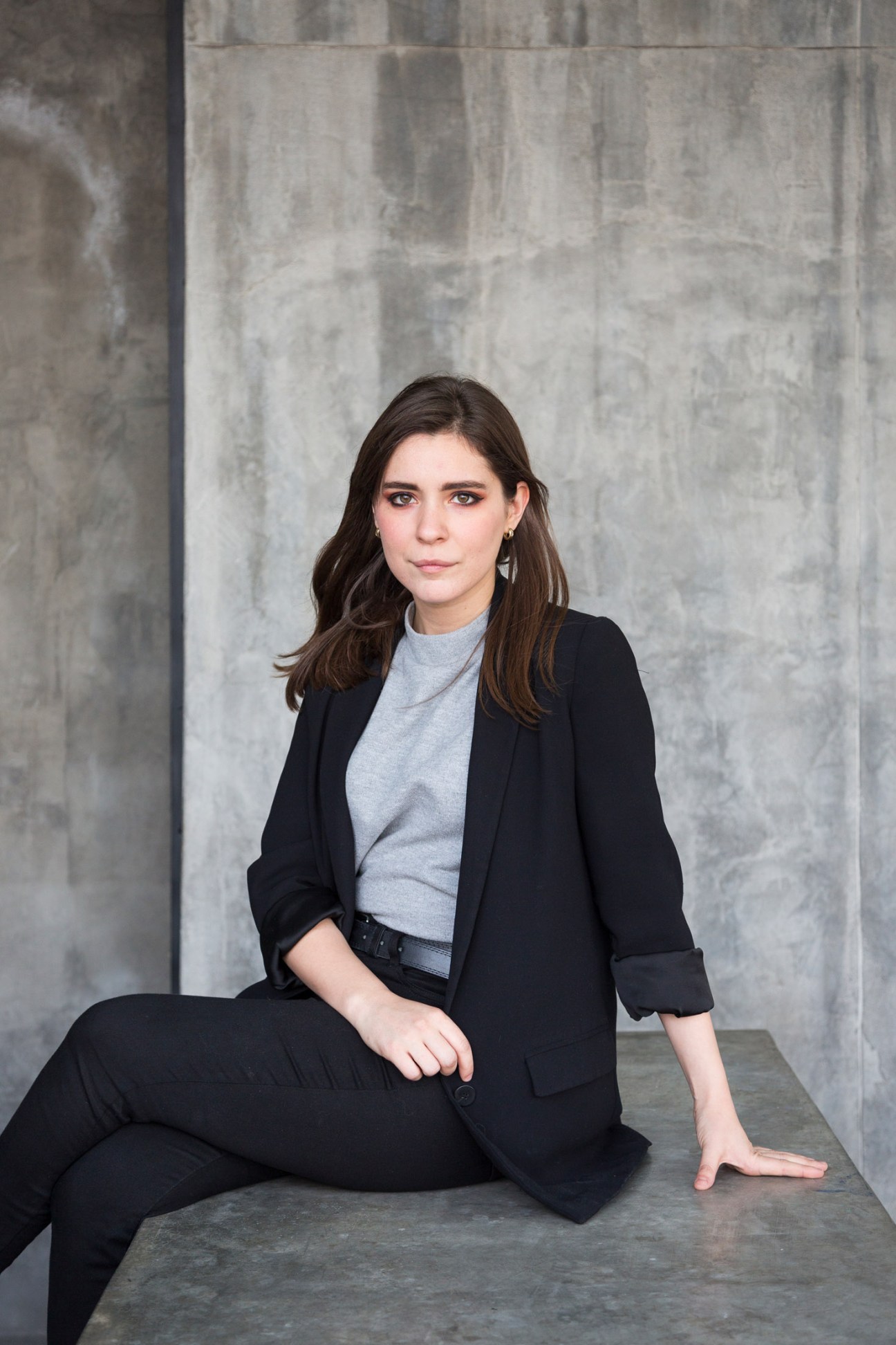 Daniela Garza, CEO and creative partner at Anagrama design studio, poses against a concrete wall.