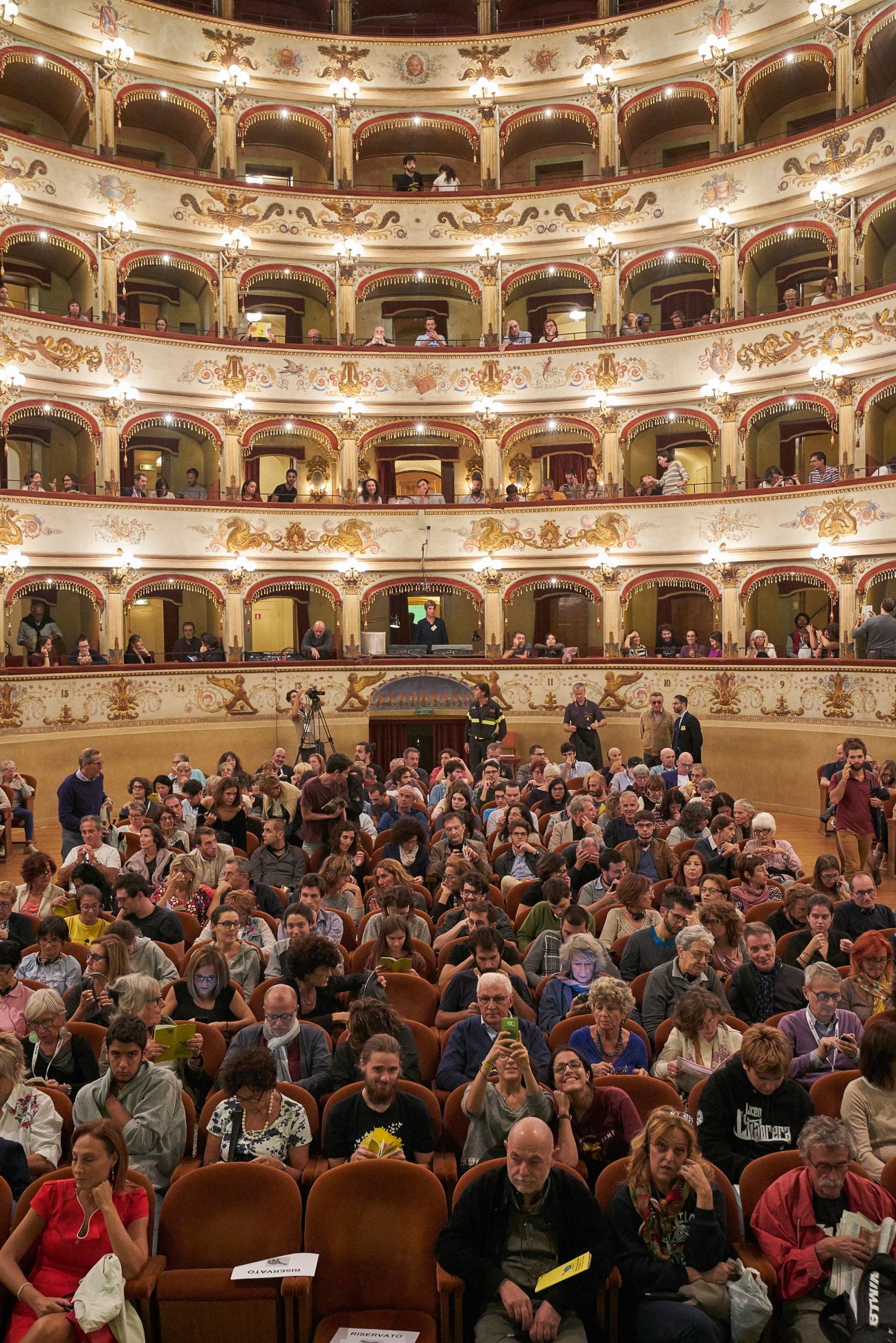 Audience seated in the ornate Teatro Comunale theater with multiple tiers of balconies during Internazionale a Ferrara festival.