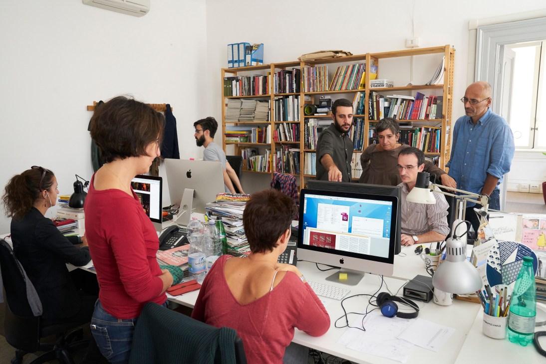 Internazionale magazine editorial staff collaborating in their Rome office among bookshelves and computers.