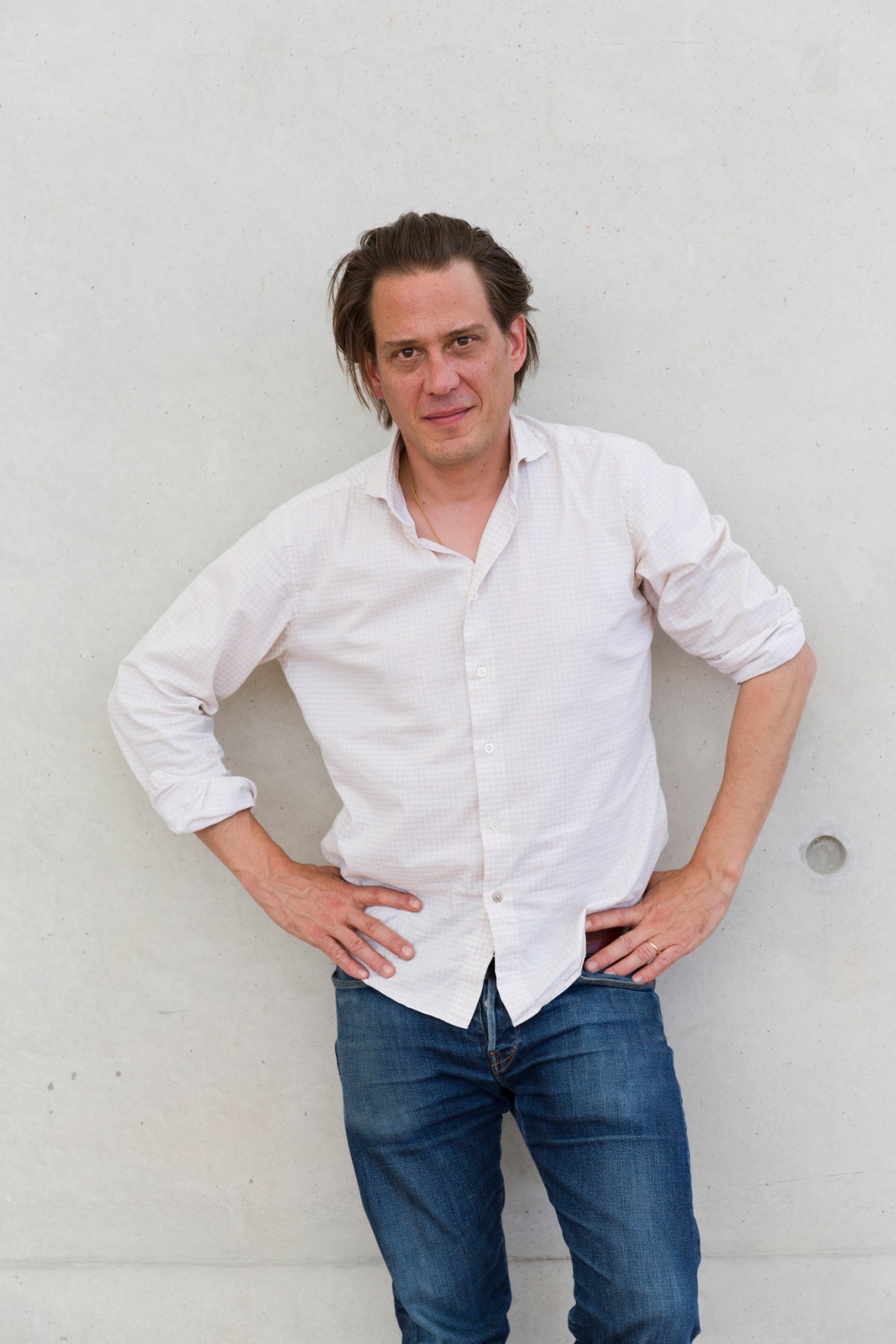 Portrait of Antoine Meunier, head of communications and media at The Camp, wearing a white button-up shirt.