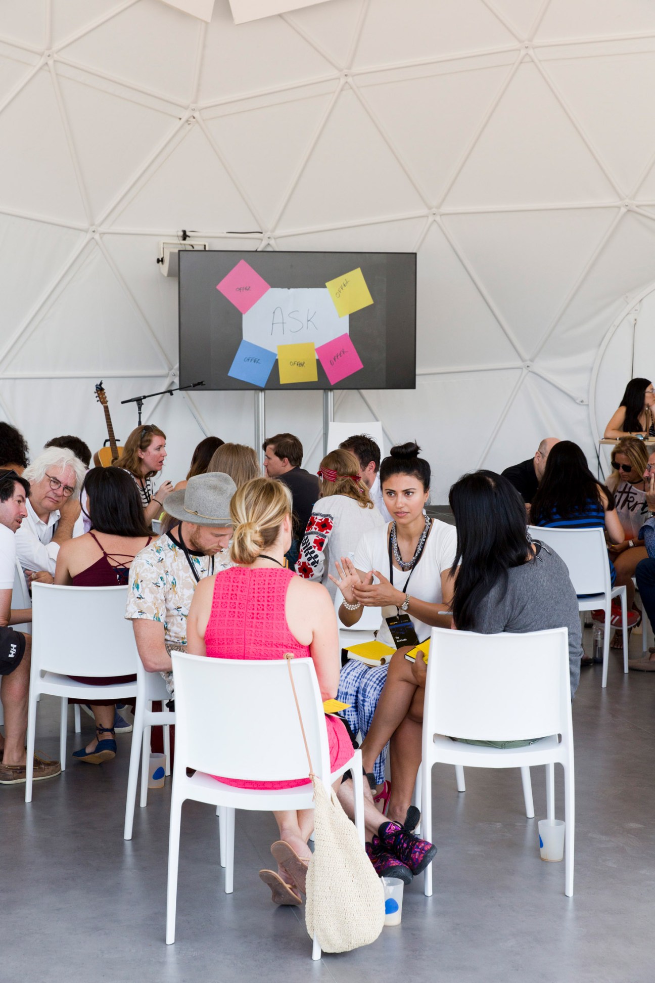 Participants at the Hatch Europe event gathered in a white pod-like meeting space with colorful sticky notes on a presentation board.