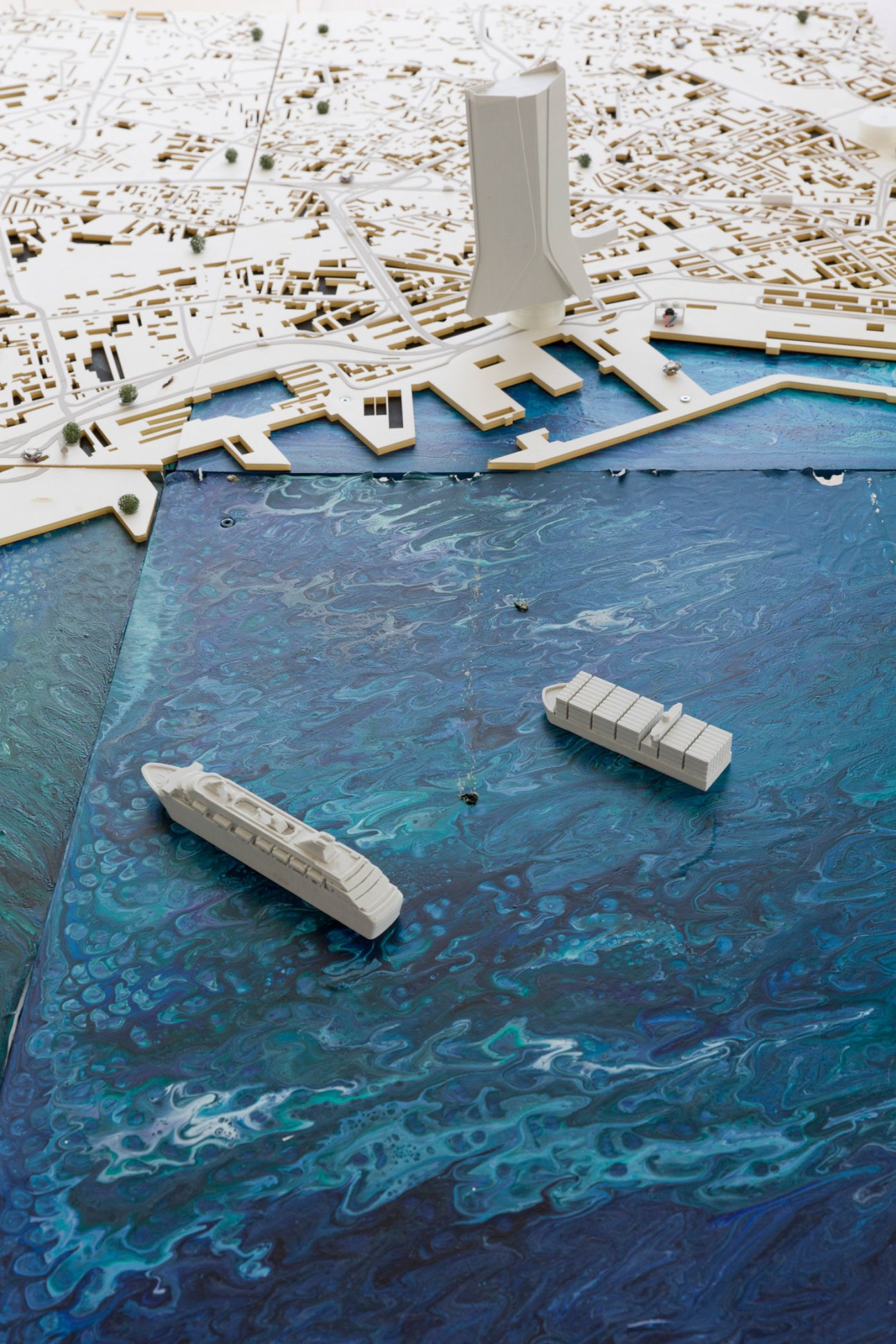 Architectural model of Marseille showing waterfront city planning with white buildings and blue water feature.