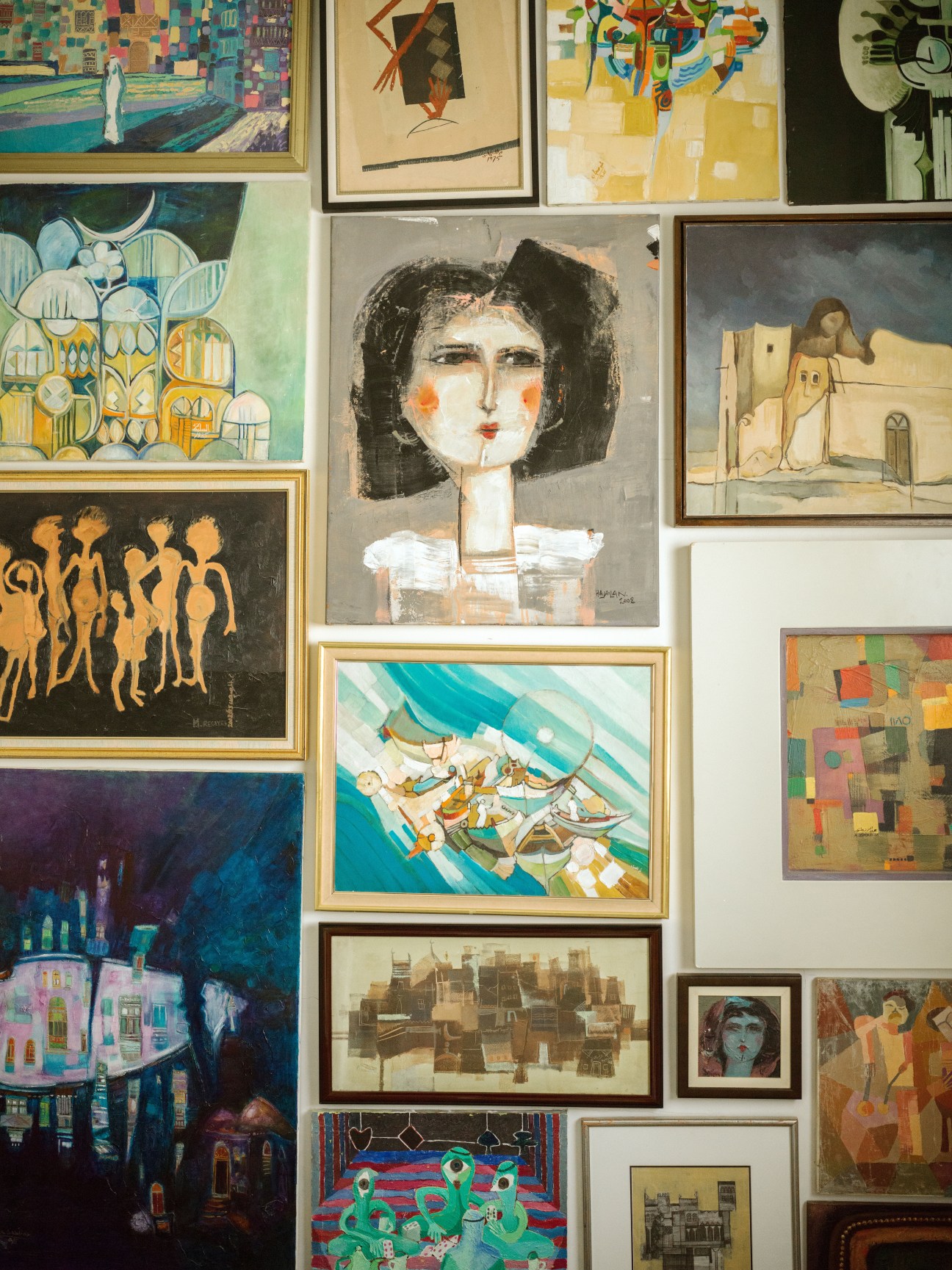 Salon-style wall display of framed artworks collected by dealer Qaswra Hafez at Hafez Gallery in Jeddah.