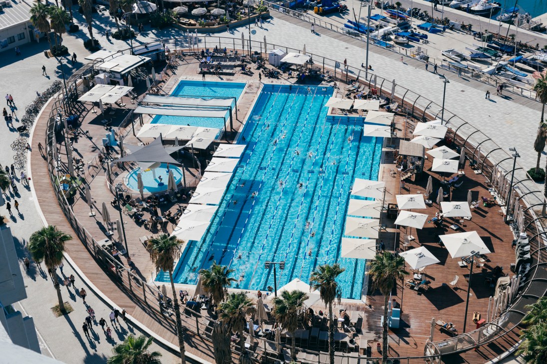 Aerial view of Gordon Pool's Olympic-size swimming pool with lane dividers and marina in background