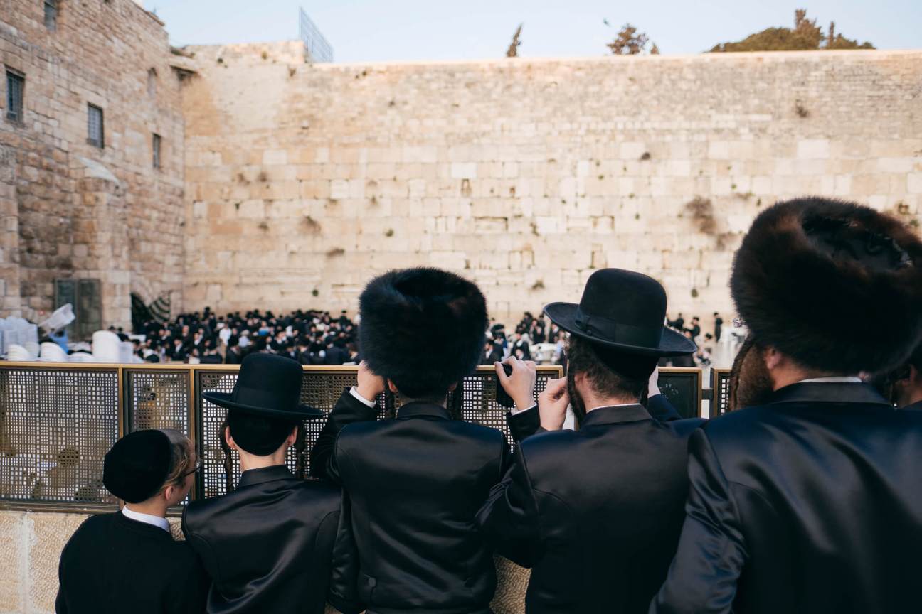 Ultra-Orthodox Jewish men in black clothing and hats at the Western Wall in Jerusalem.
