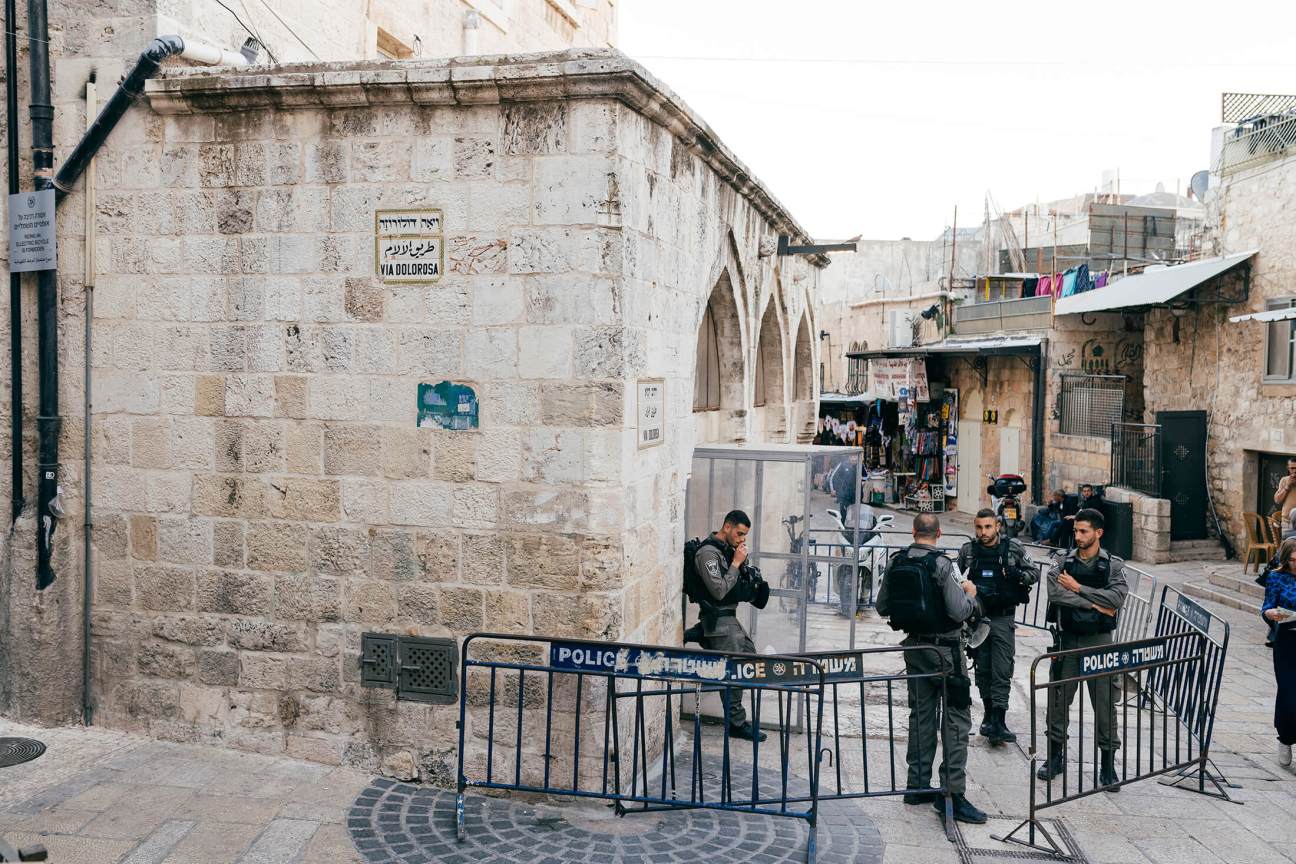 Jerusalem police officers stand guard behind barriers on the Via Dolorosa in the Old City.