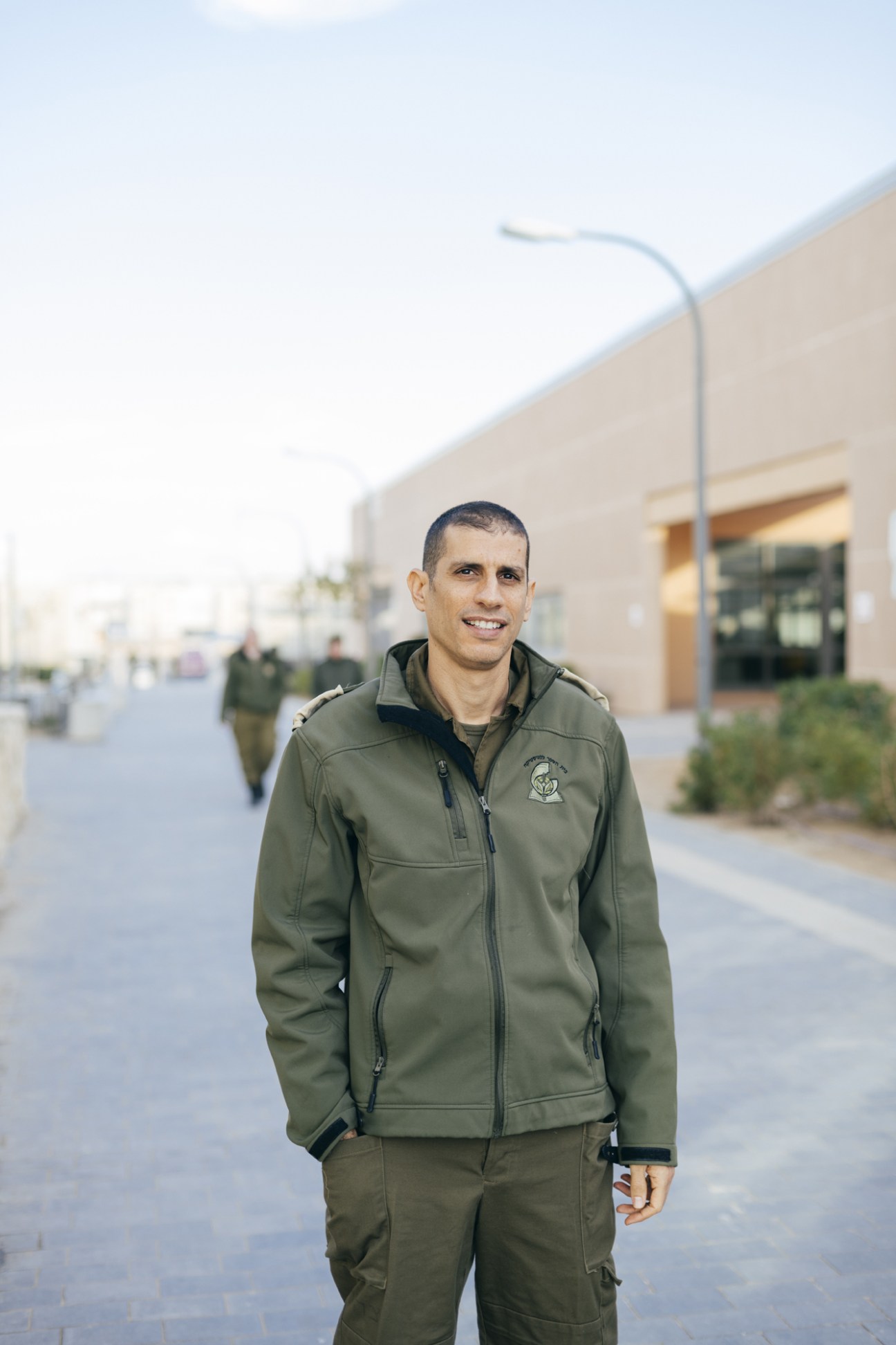 Dror Malal, an IDF driving instructor, stands in military uniform in front of the School of Logistics building at Ir Habahadim base.