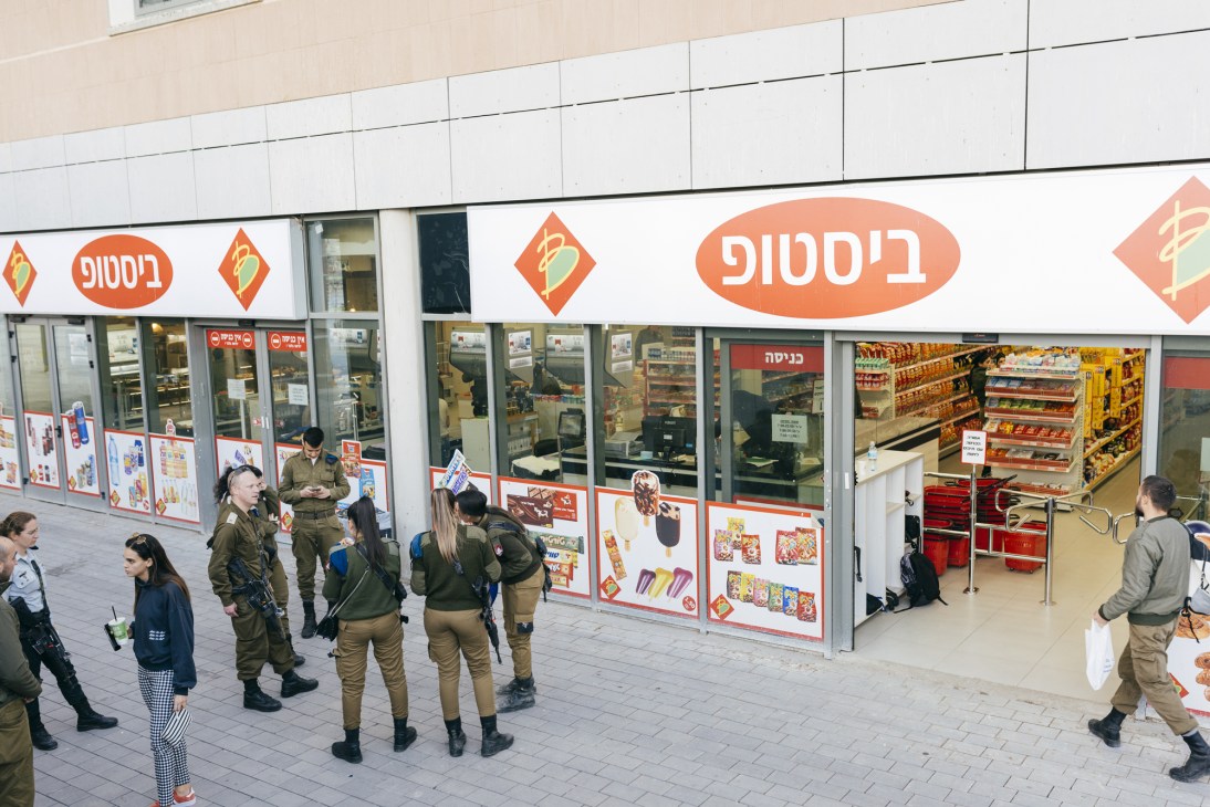 IDF soldiers and civilians outside a Bistouf supermarket storefront at Ir Habahadim shopping centre.