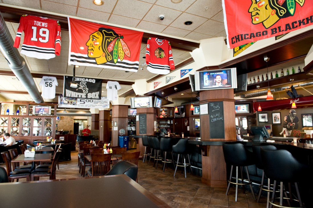 Interior of Kroll's bar and grill with Chicago sports memorabilia and team jerseys displayed on ceiling