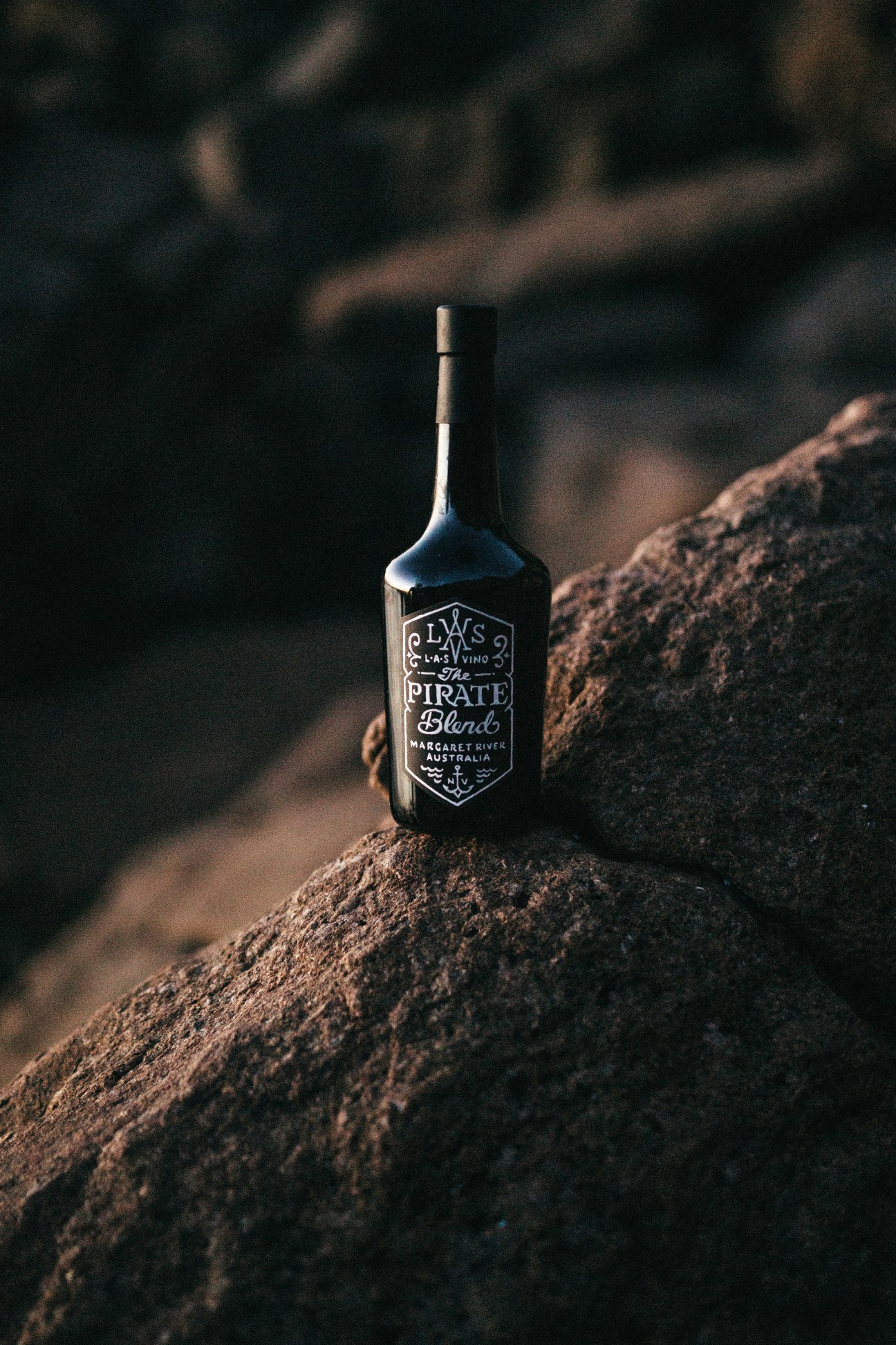 Las Vino's The Pirate Blend wine bottle positioned on rocky terrain with blurred background.