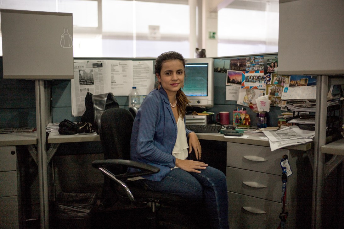 Isayen Herrera, a senior health reporter at Venezuela's opposition newspaper, sits at her desk in a newsroom office