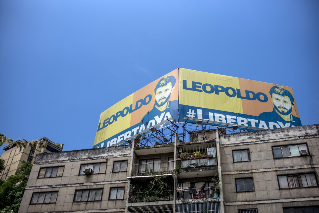 Large billboard featuring Leopoldo López's portrait with text calling for his freedom mounted on apartment building