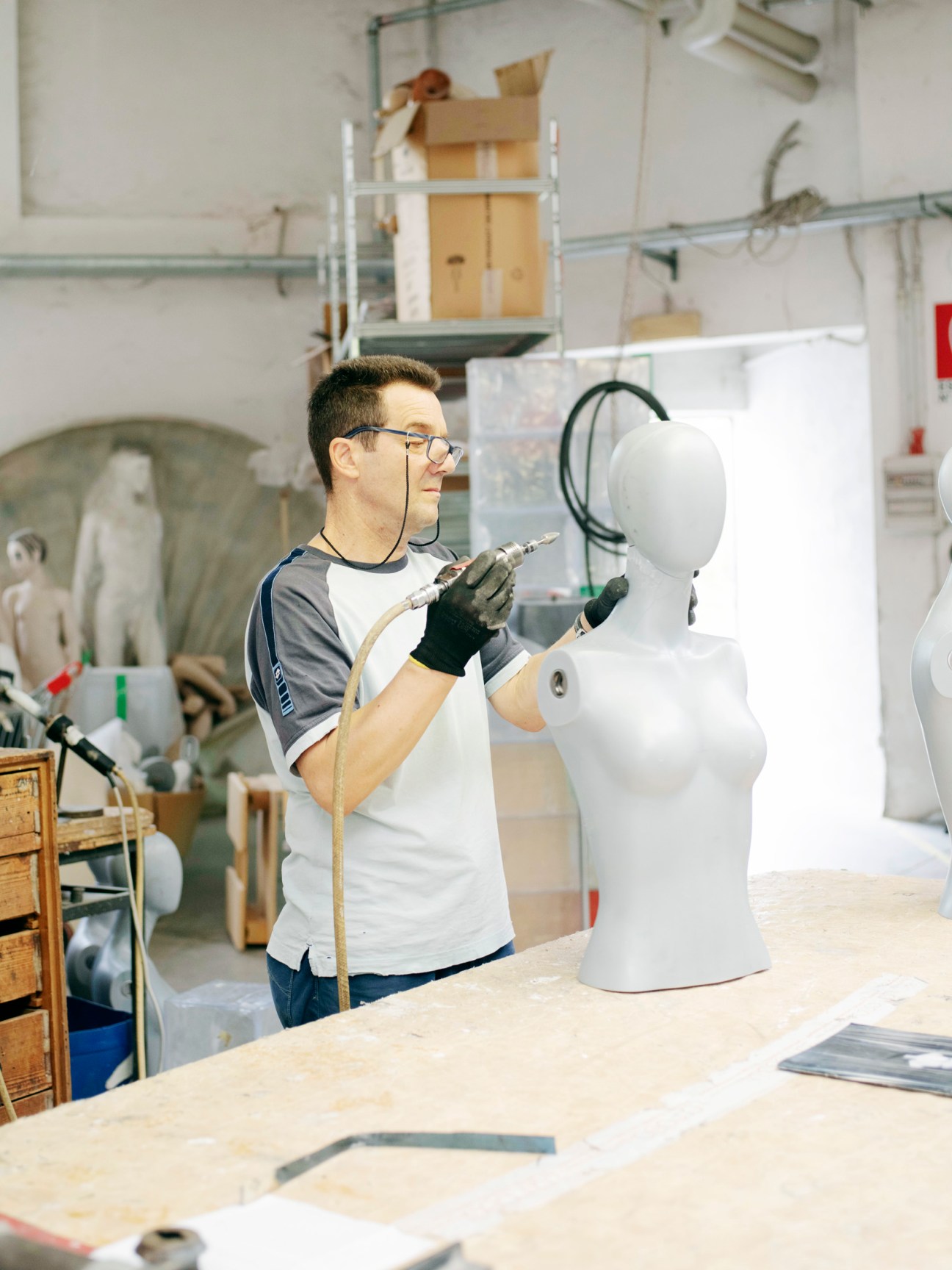 La Rosa worker applies finishing touches to a white mannequin head at the Milan factory.
