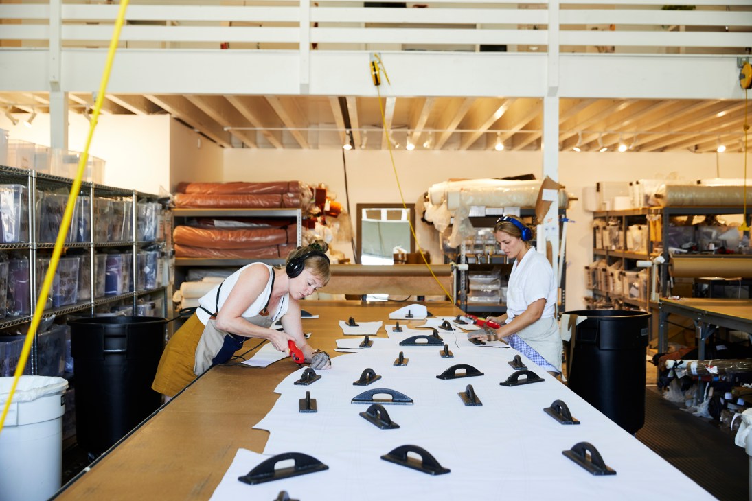 Two workers cut and prepare fabrics at Elizabeth Suzann's Nashville factory.