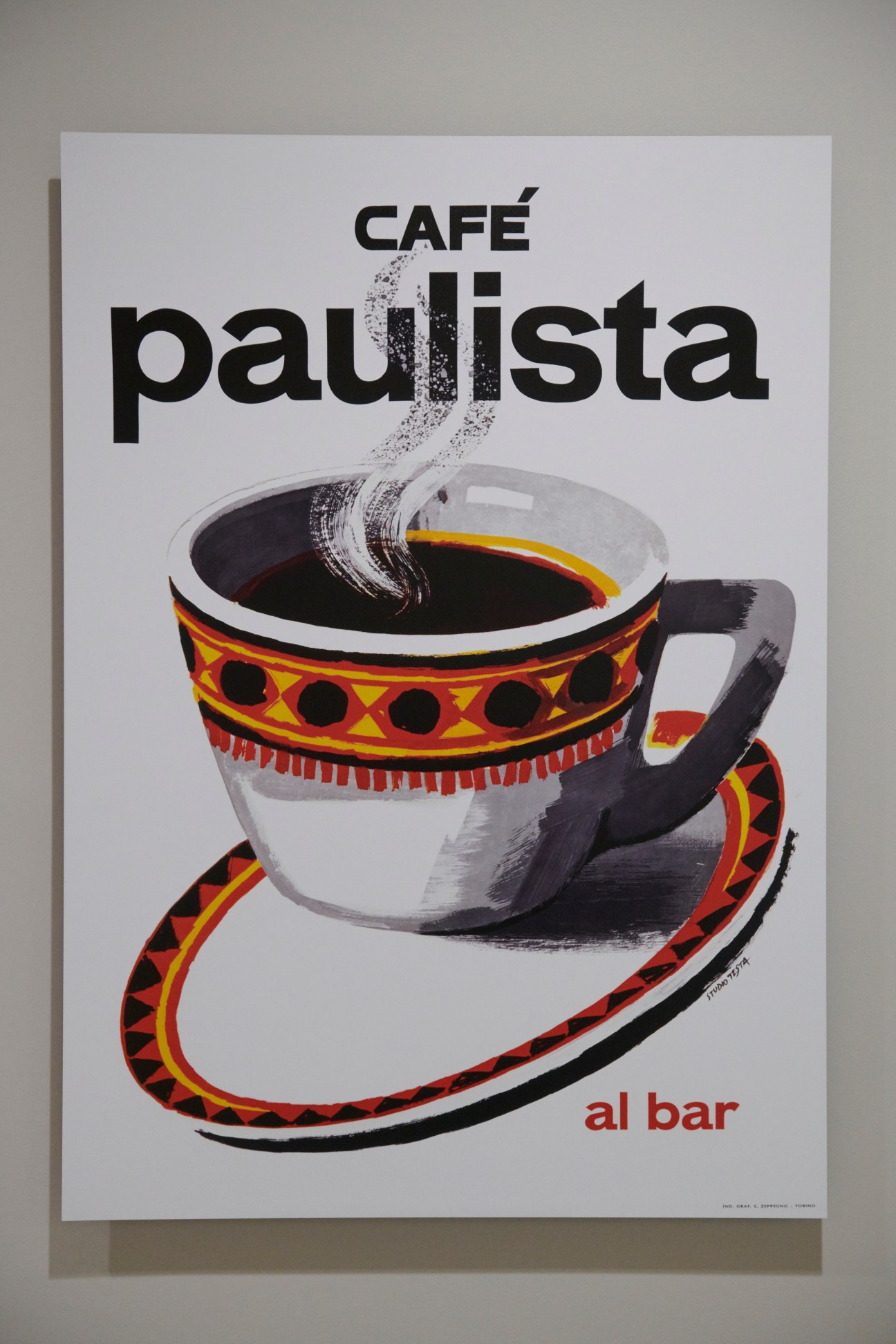 Vintage coffee advertisement poster showing illustrated coffee cup with decorative pattern and 'Café paulista al bar' text
