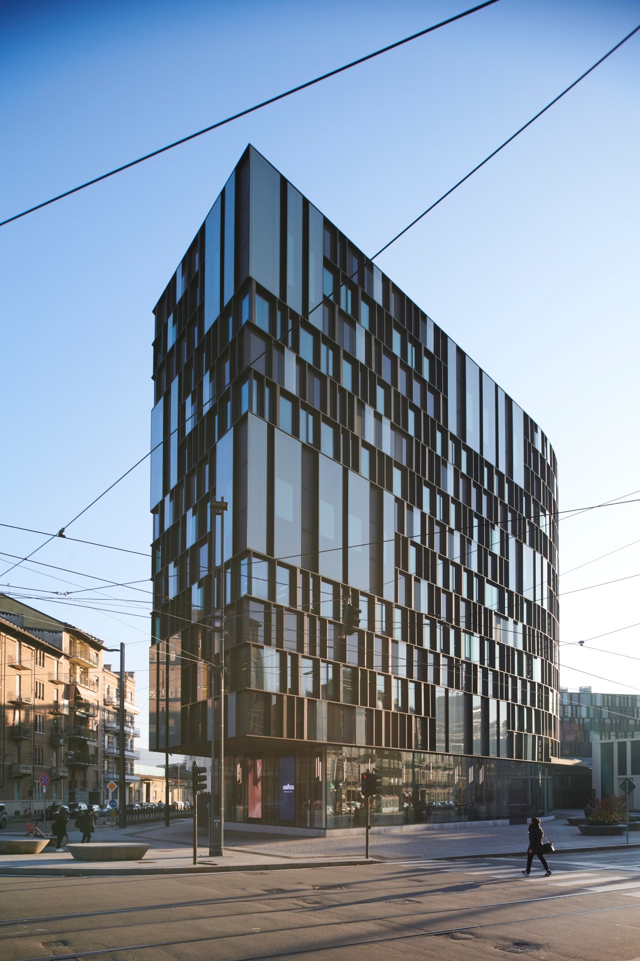 Modern office building with geometric bronze and rust colored facade panels and vertical ribbon windows