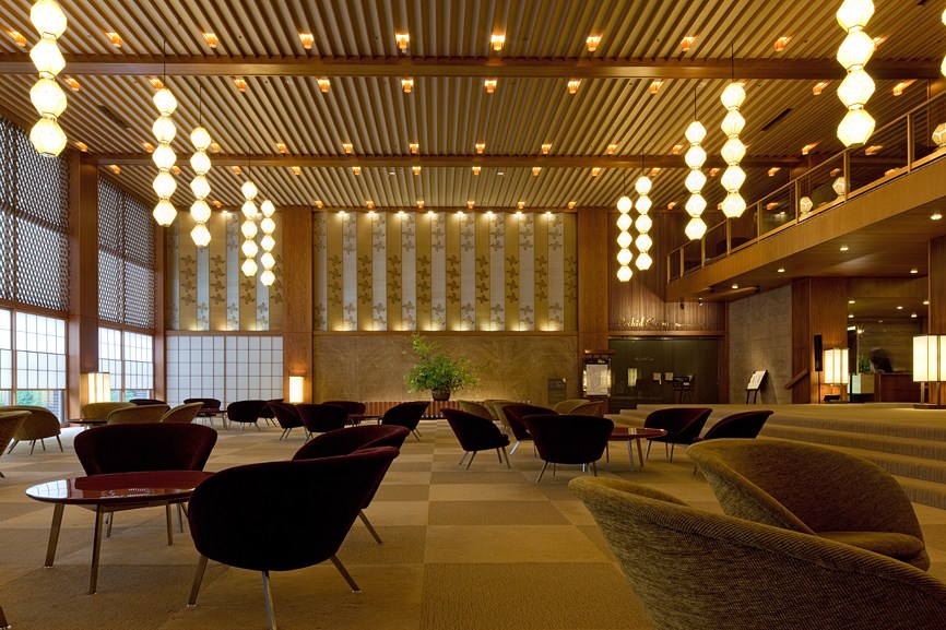 Hotel Okura's 1960s lobby featuring pendant lights, modernist furniture, and geometric flooring design.