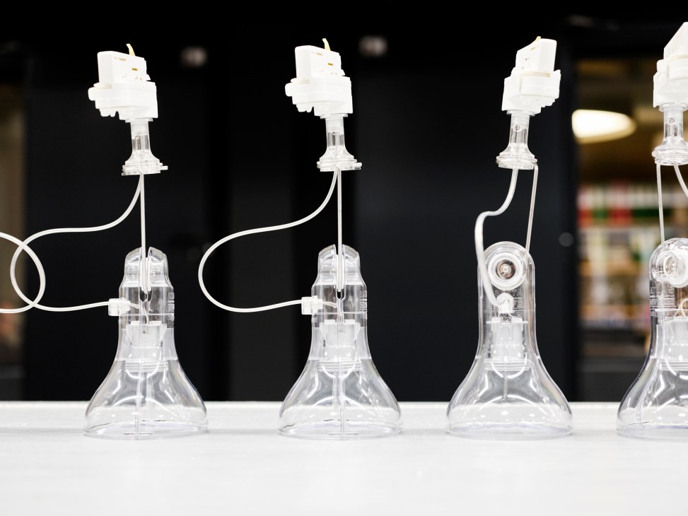 Clear glass pendant lamps being assembled on a production line with white cables and components