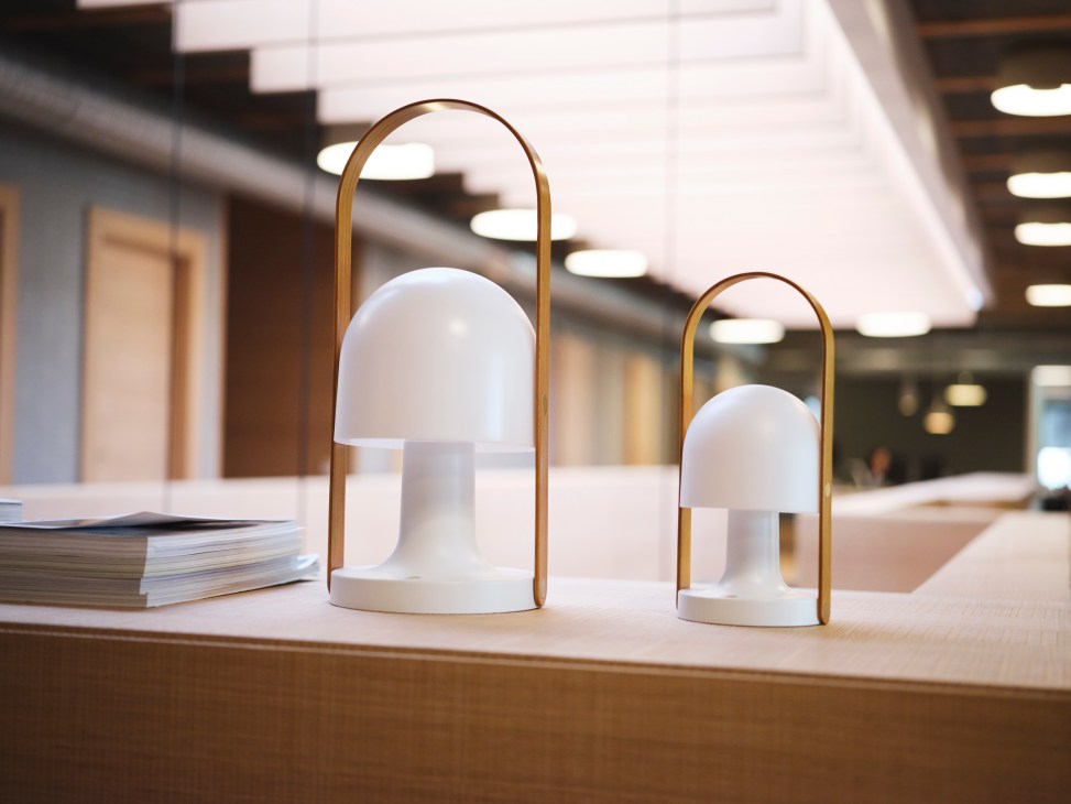 Two FollowMe portable table lamps with white shades and brass handles on a wooden desk