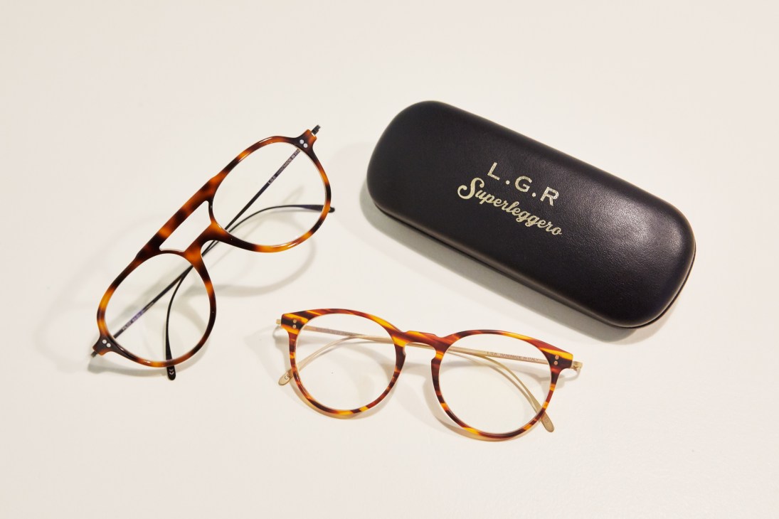 Two tortoiseshell-patterned eyeglasses and a black LGR Superleggero case on a white surface.