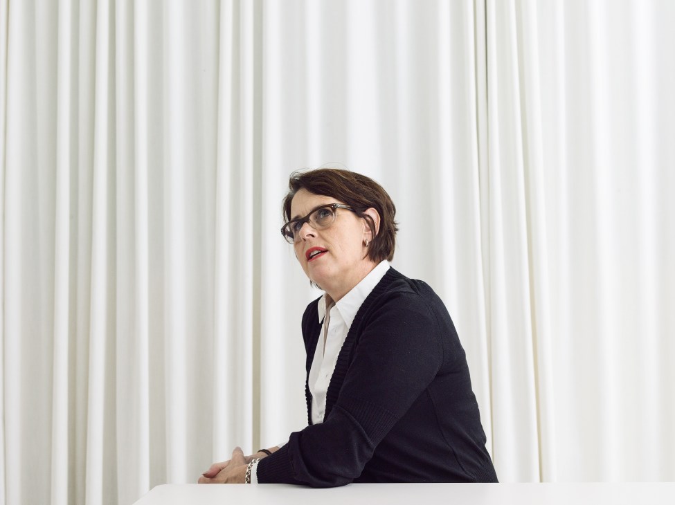 Mirkku Kullberg, CEO of Artek, wearing glasses and dark blazer against white curtains.
