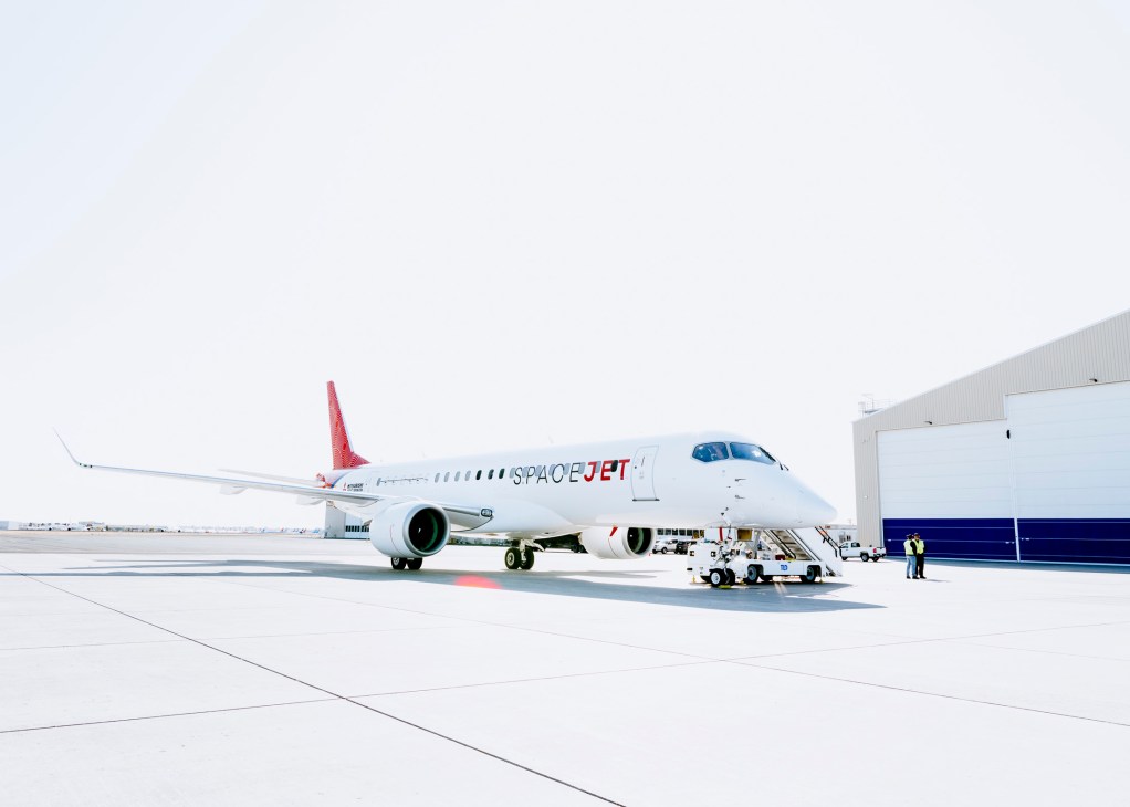 SpaceJet M90 aircraft positioned on tarmac with crew conducting pre-flight preparations