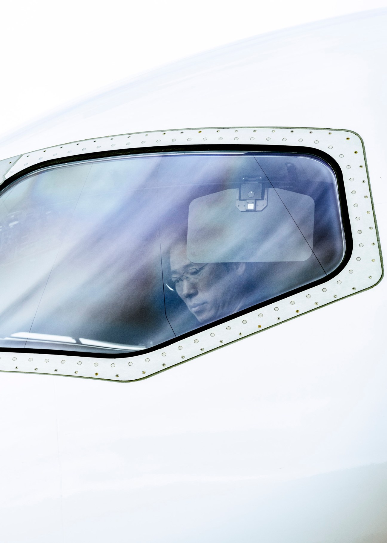 Test pilot visible through aircraft window during post-flight shutdown procedures