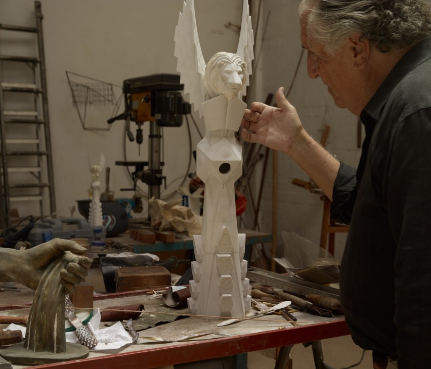Sculptor Xavier Medina Campeny works on an ornate white stone carving in his workshop studio.