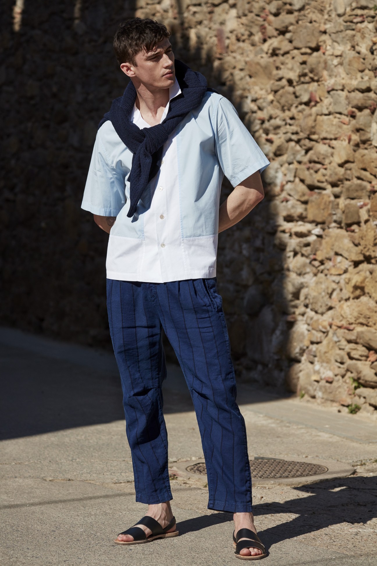 Male model wearing white shirt, navy scarf, and blue checkered trousers by Massimo Alba with Hereu sandals.