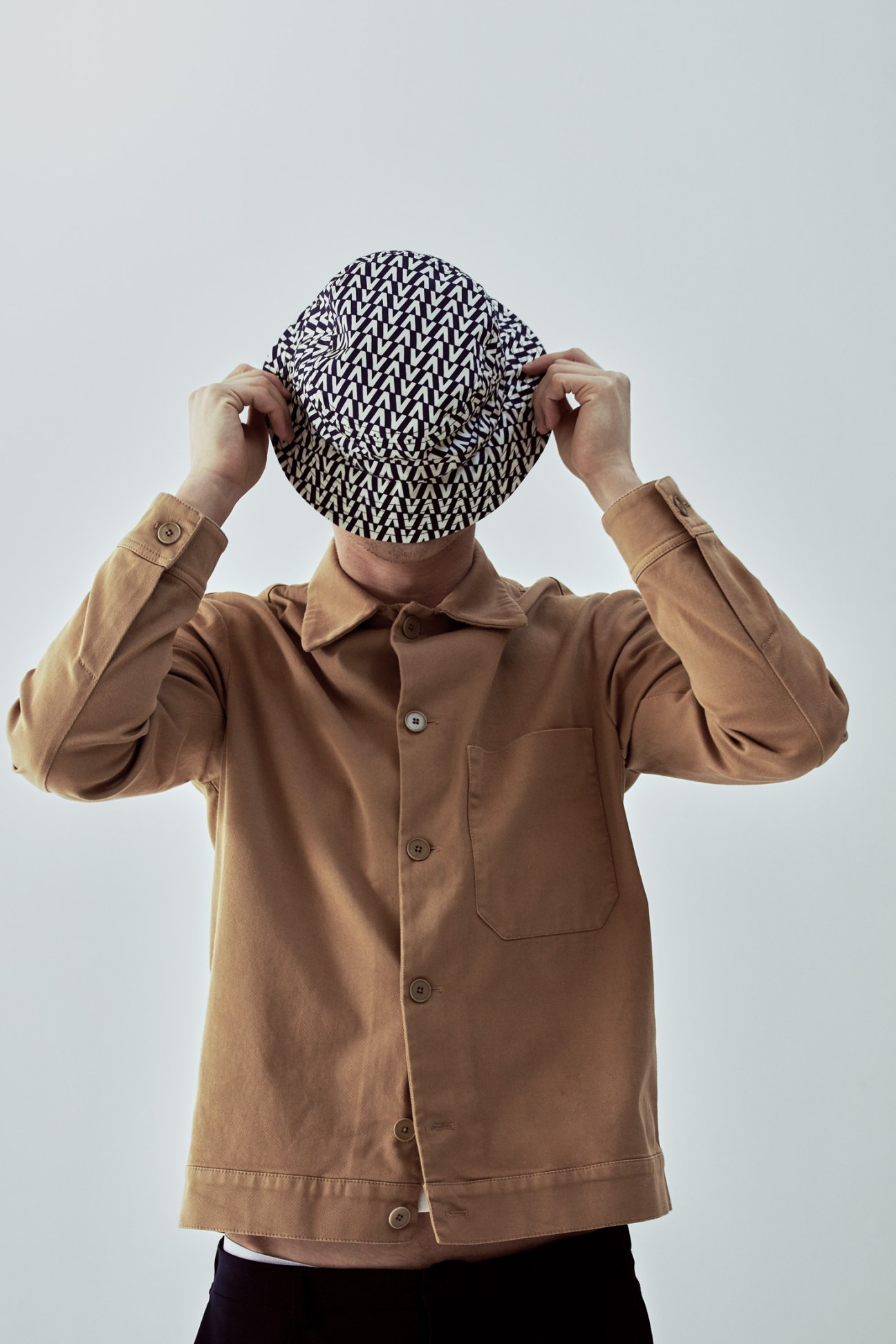 Model wearing a tan Barena Venezia jacket and black patterned Valentino hat.