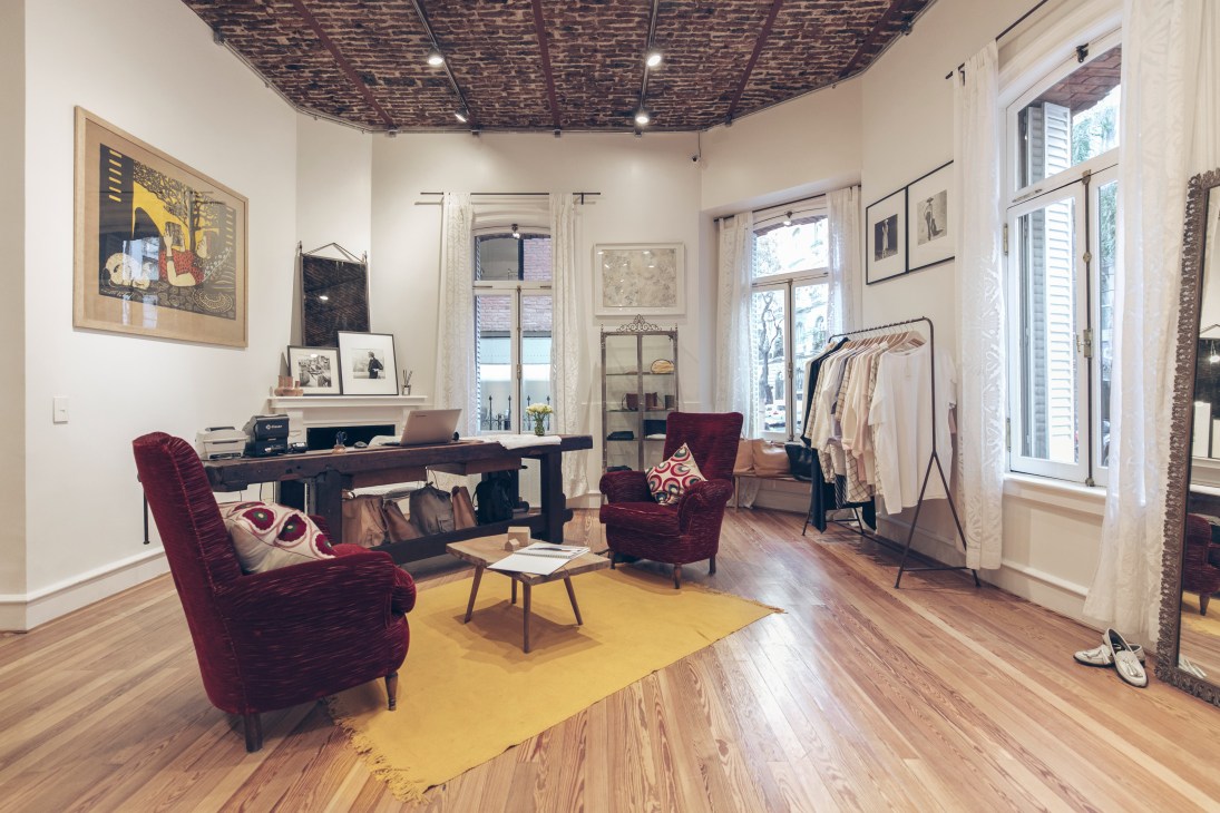 Interior of Blue Sheep showroom with burgundy velvet chairs, clothing rack, and minimalist decor in Palermo Botánico.