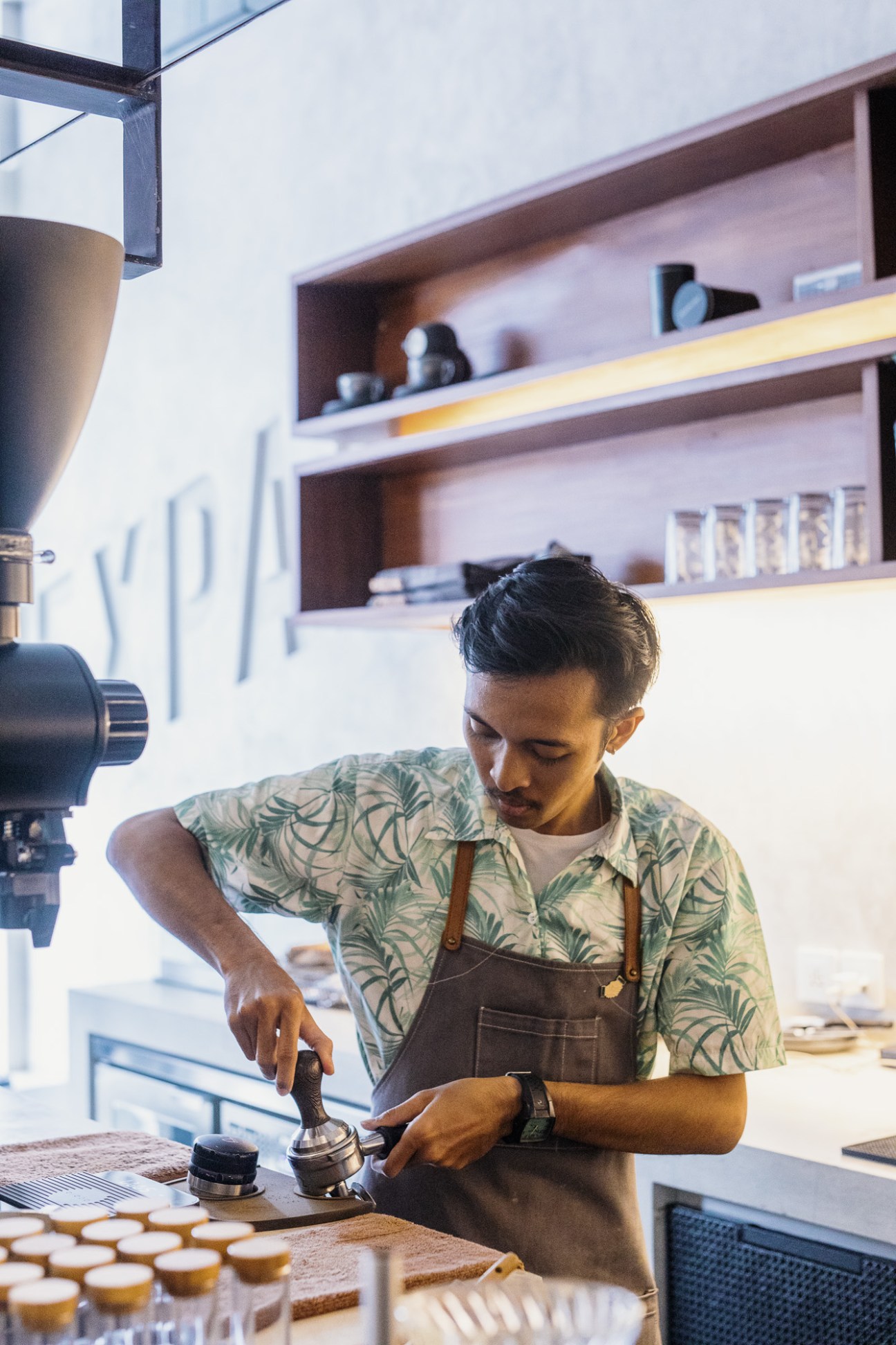 A person working at Expat Coffee roastery in Bali with coffee equipment