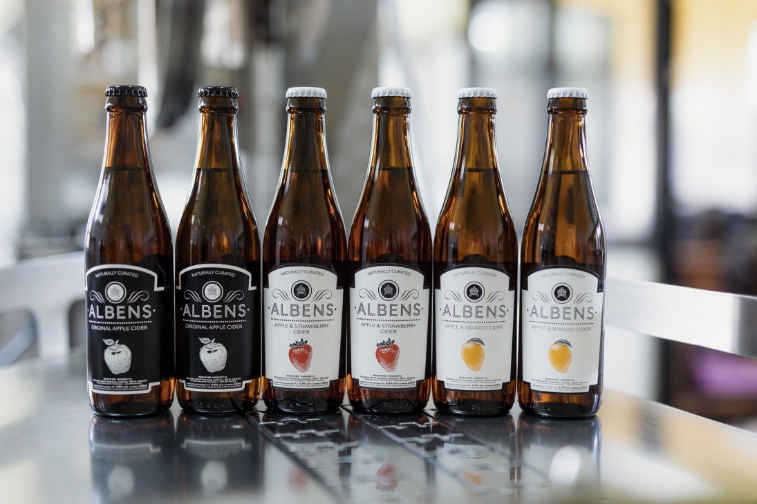 Various flavoured bottles of Albens cider lined up showing different varieties
